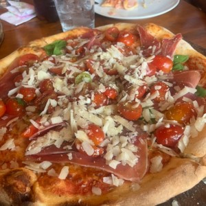 Pizza con arugula, tomates cherrys y jamon serrano