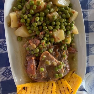 ossobuco con papas y guisantes y polenta