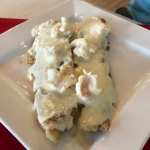 Filete de corvina con crema de mariscos encima 