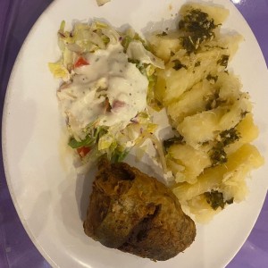 Pescado relleno (centro) con yuca al mojo y ensalada de la casa.