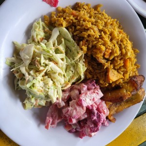 Arroz con puerco con ensalada de repollo y tajadas