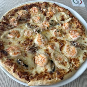 Pizza de mariscos mixtos en salsa blanca.