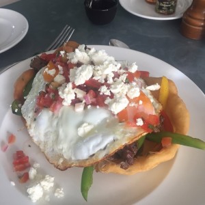 Huevo Frito sobre Filete de Res encebollado, pico de gallo, hojaldre y queso feta