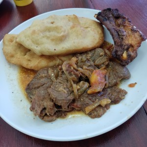 Bistec encebollado, hojaldre y costilla