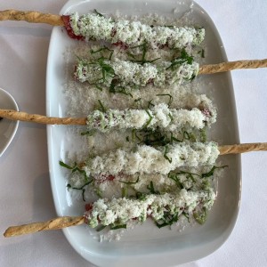 Carpaccio de filete de res sobre grissini, mayopesto y lluvia de parmensano