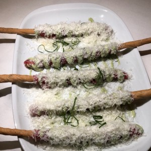 Carpaccio de filete de res sobre grissini, mayopesto y lluvia de parmensano