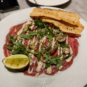 Carpaccio de Res, Creminis Asados, Parmesano D.O.P., y Mayonesa de Trufa Negra