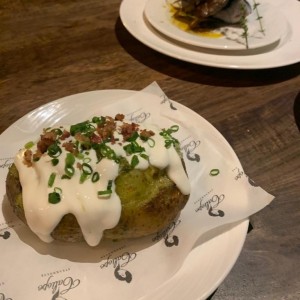 Papas Asadas con Toque de Chimichurri, Tocino, Queso Cheddar, Crema Agria y Cebollina