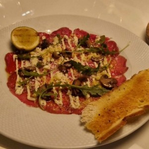 Carpaccio de Res, Creminis Asados, Parmesano D.O.P., y Mayonesa de Trufa Negra