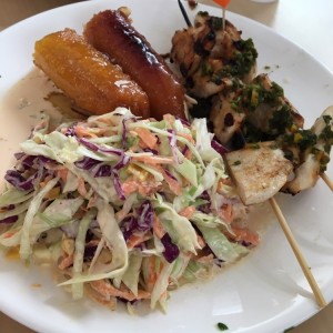 Brochetas de pollo, ensalada rallada, platano a la almendra