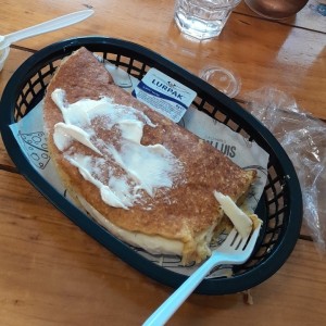 cachapa con queso y carne mechada y crema por encima.