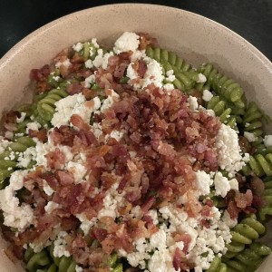 Fusilli al pesto con feta, tomate cherry y tocino