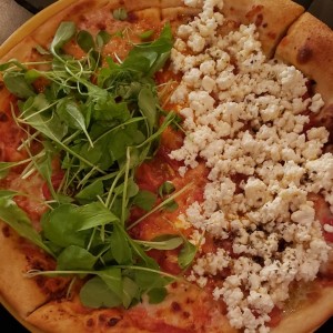 pizza mitad tomate y rucola y mitad feta con miel