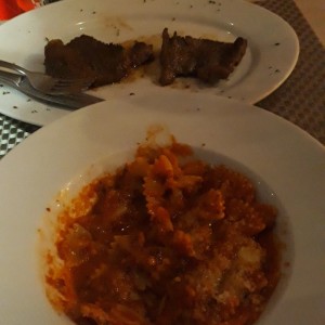 Filete con pasta en salsa arrabiata.