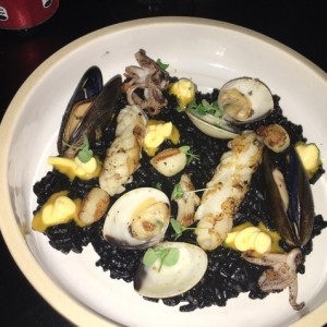 Rissoto nero con calamares, almejas y mejillones flambeados en brandy