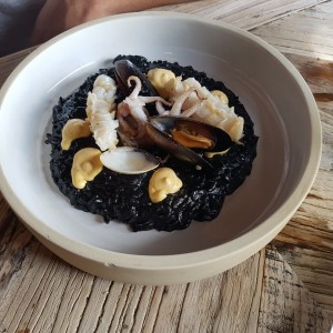 Rissoto nero con calamares, almejas y mejillones flambeados en brandy