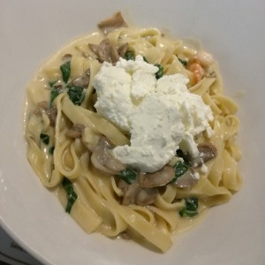 Fetuccini con salsa alfredo, camarones, queso de cabra y espinacas.