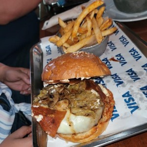 LA CONFIDENCIAL (ganadora Burger Challenge 2018, viene con puerro/hongos salteados en mantequilla, mayonesa de queso cabra/berenjenas, cuajado de queso/prosciutto para un toque crujiente, en pan artesanal de papa), con papas fritas.