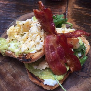 Tostadas de Aguacate, queso Feta, huevo revuelto y maple bacon 