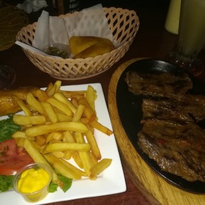 Filete de res, empanadas de carne con chimichurri y papas fritas con ensalada de lechuga y tomate