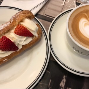 eclair de fresas con una taza de cappucino