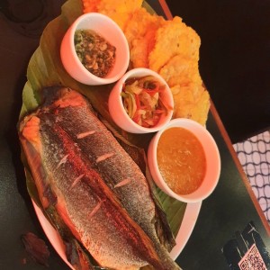 Corvina al horno en hoja de Bijao con patacones, Tamal de Olla,  escabeche, ajillo 