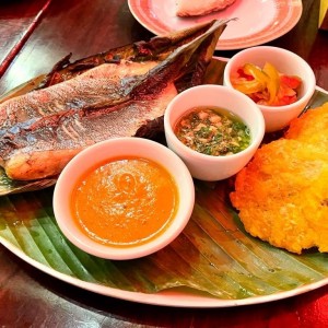 Corvina en Bijao con Polenta, Encurtido, Ajillo y Patacones