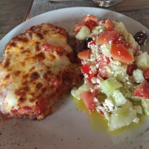 Pollo a la parmesana con ensalada griega.