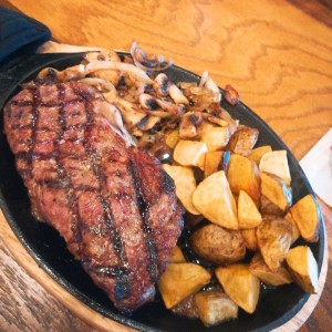 Filete Bourbon con cebolla y hongos salteados y papas