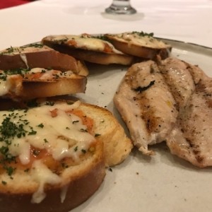 pechuga de pollo acompaada de bruschetas de tomate. 