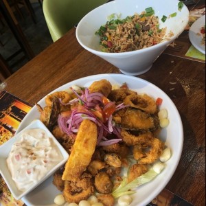 Jalea de Mariscos(con yuca y choclo); Detras: Chaufa mixta(contiene carne y mariscos)  