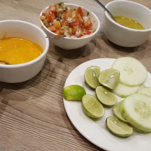 Salsas roja y verde picante, pico de gallo, limones y pepinos