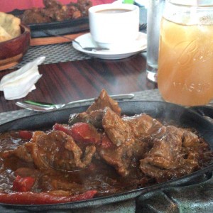 bistec encebollado con chicha de raspadura