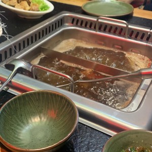 Hot pot con separaciones, ambos caldos de hongos, usamos un lado para la proteina animal y el otro lado para los vegetarianos.