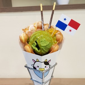 Egg waffle gelato, helado de matcha, popping bubble de rosa y mango, topping de caramelo y pepero de chocolate