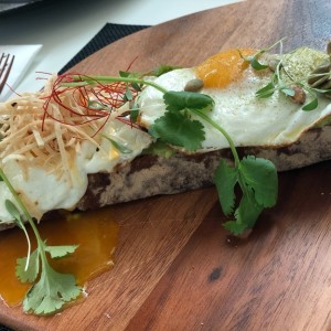 Tostada con una cama de aguacate y huevo