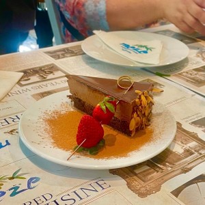 CHOCOLATINA (Tradicional pastel de Atenas conformado de tres capas, esponjoso bizcocho, mousse y ganache de chocolate al estilo griego decorado con almendras y fresas)