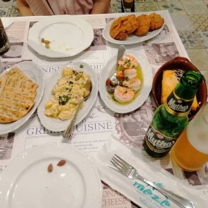 Croquetas de tomates, ensalada de papas, pan pita, langostinos y queso feta en pasta filo