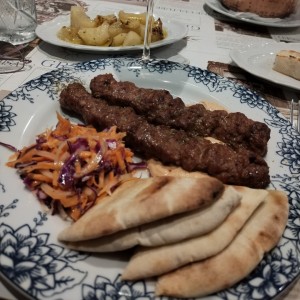 Pinchos de cordero con pan pita y ensalada de la casa. 