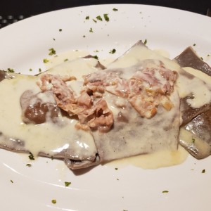 Ravioli de cacao con ricotta, pera y prosciutto