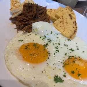 Huevos con carne mechada y arepa 