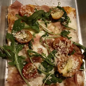 Pizza de arugula y tomates