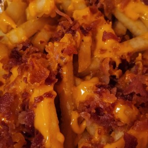 Papas con queso cheddar y bacon