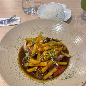 LOMO SALTADO (Tiras de filete de res salteados al momento con cebolla, tomate y papas fritas)