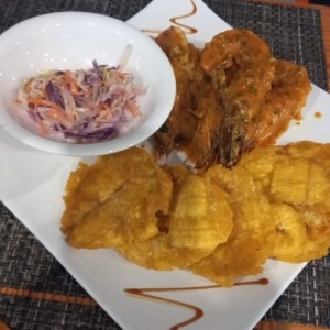 Langostinos al ajillo, patacones y ensalada coleslaw