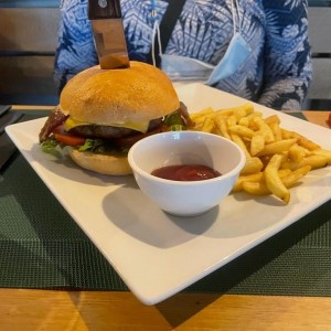 BURGUER DEL CHEF (200 grs de carne Dry Aged, queso cheddar gruyere, bacon glaze, cebolla caramelizadas, rugula, tomate y mayo de la casa) con Papas Fritas