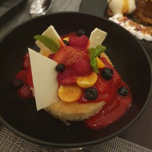 Baba au rhum, bizcocho remojado en jarabe de de ron, con crema de vainilla y frutas de temporada