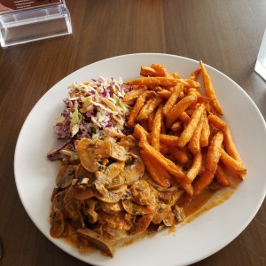 Filete de pollo con hongos, camote frito y ensalada de repollo.