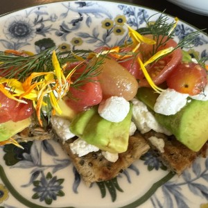 Tostadas de aguacate y queso de cabra con tomates confitados