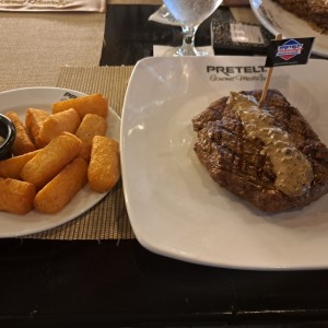 Filete de carne con yucas fritas.